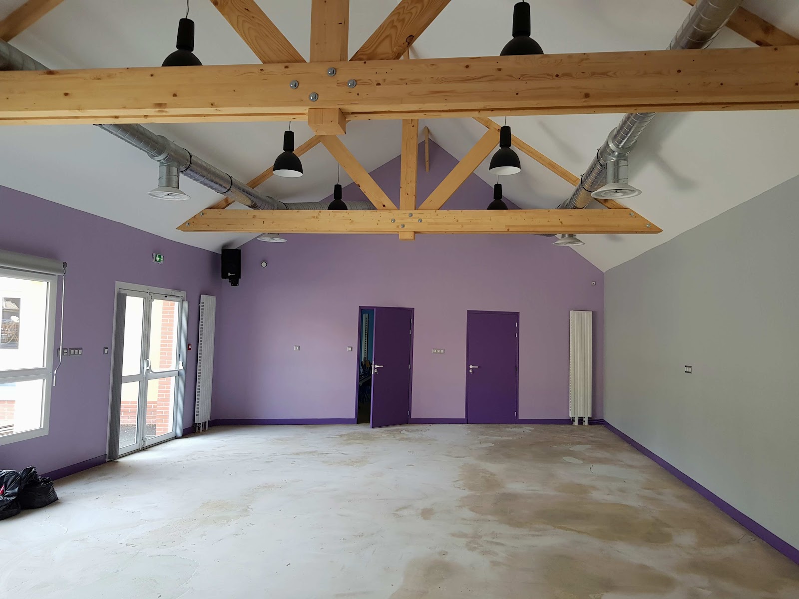 Aménagement intérieur avec charpente bois apparente réalisé par Langlois Électricien à Gisors
